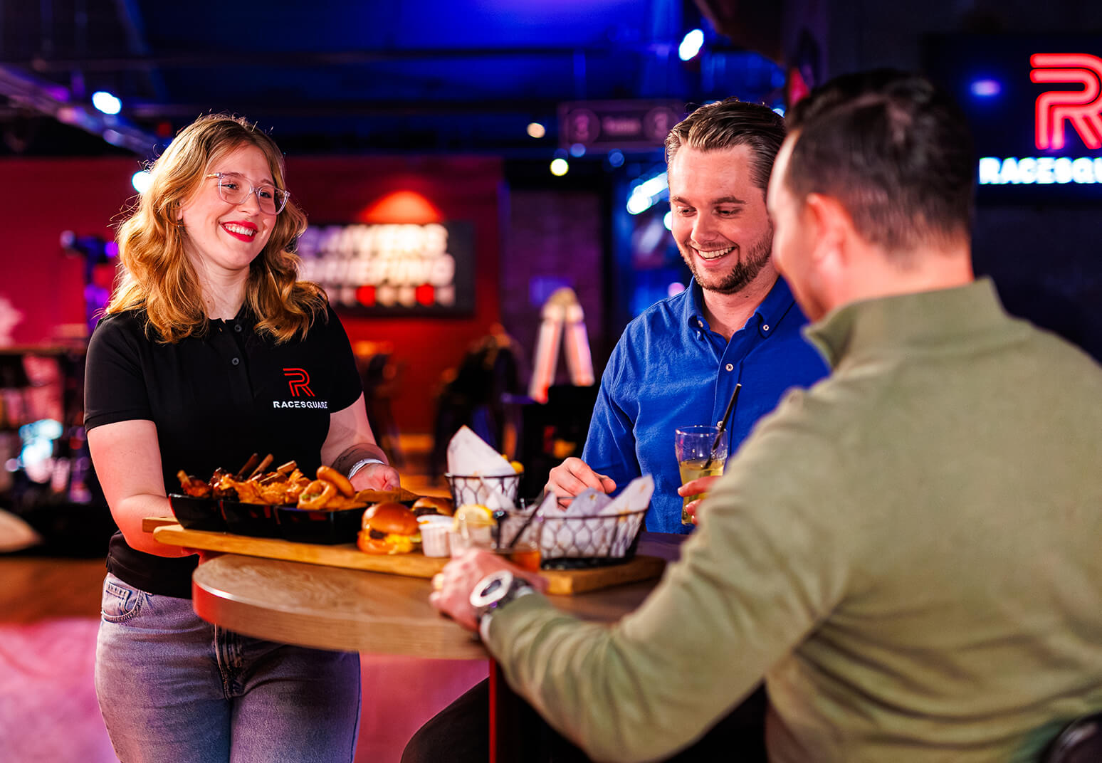 Een groep collega's proost samen na een spannende racesessie bij Racesquare.