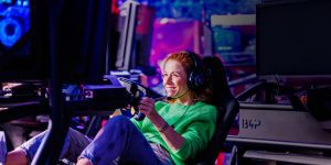 Vrouw in racesimulator bij Racesquare, volledig gefocust tijdens een spannende simrace-ervaring.